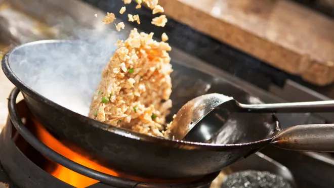 Kỹ thuật lắc chảo điêu luyện giúp hạt cơm tơi xốp và thấm đều gia vị